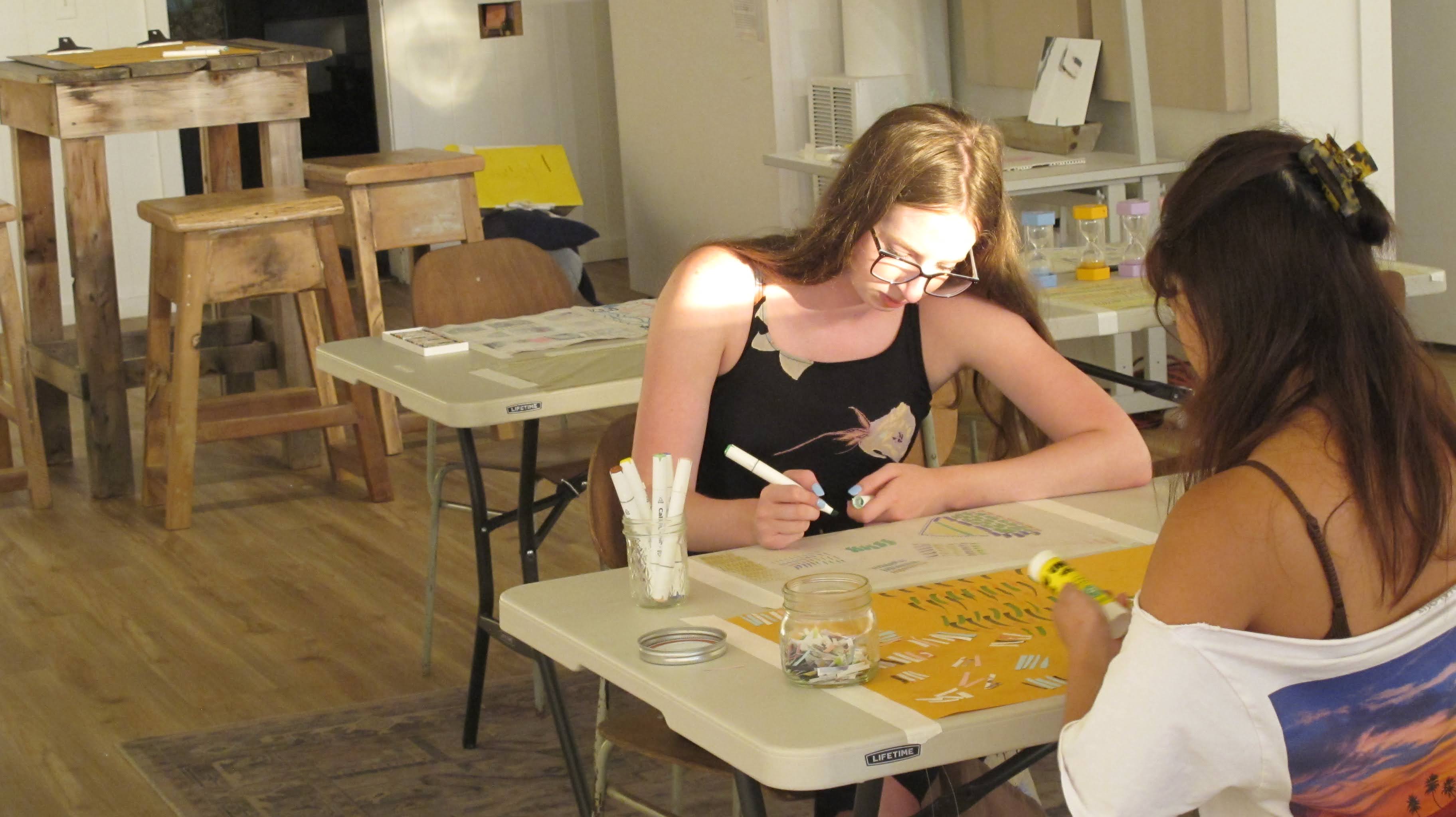 image of two friends making marks on paper